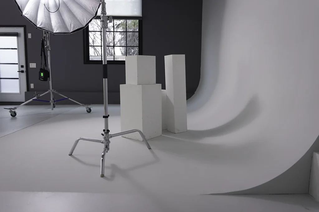 stands, posing boxes, and light sitting on cyclorama wall at studio 342 for rent 