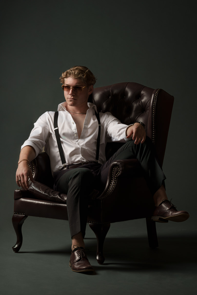 model posing on wingback chair - camera gear for rent