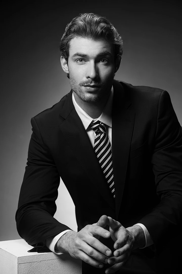 man posing with suite for black and white portrait - photo studio