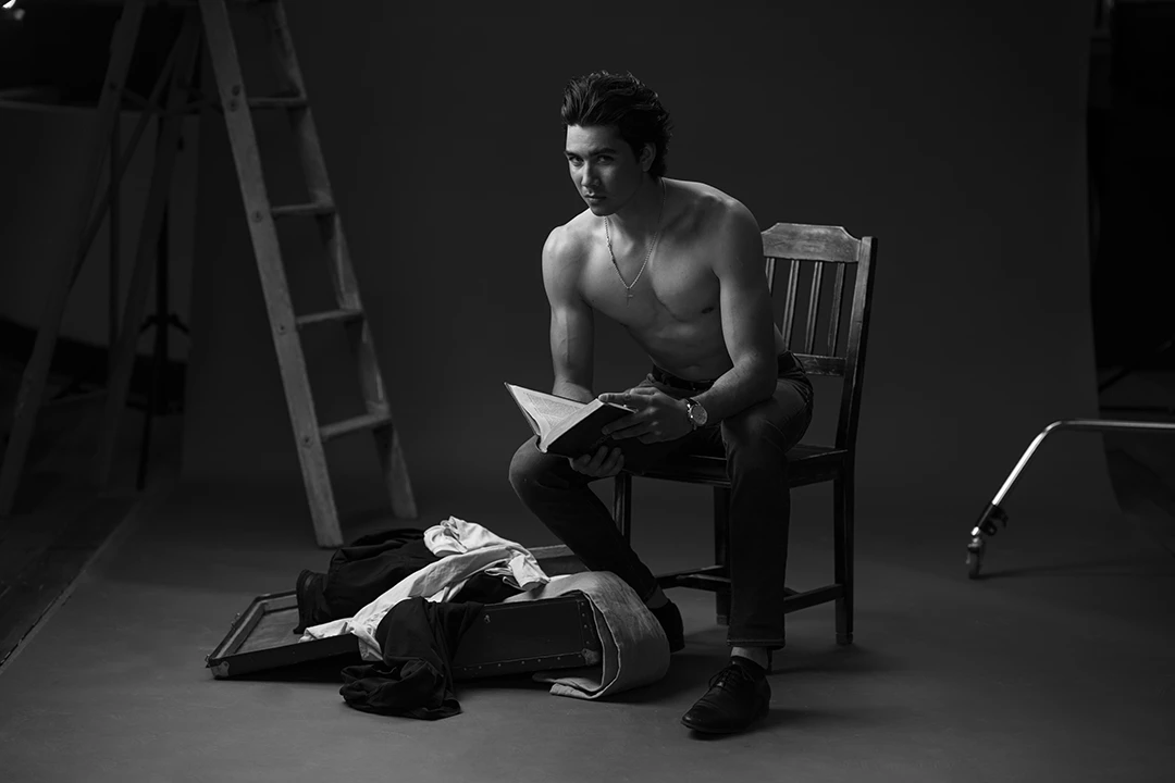 man posing on chair with books - portrait photo studio